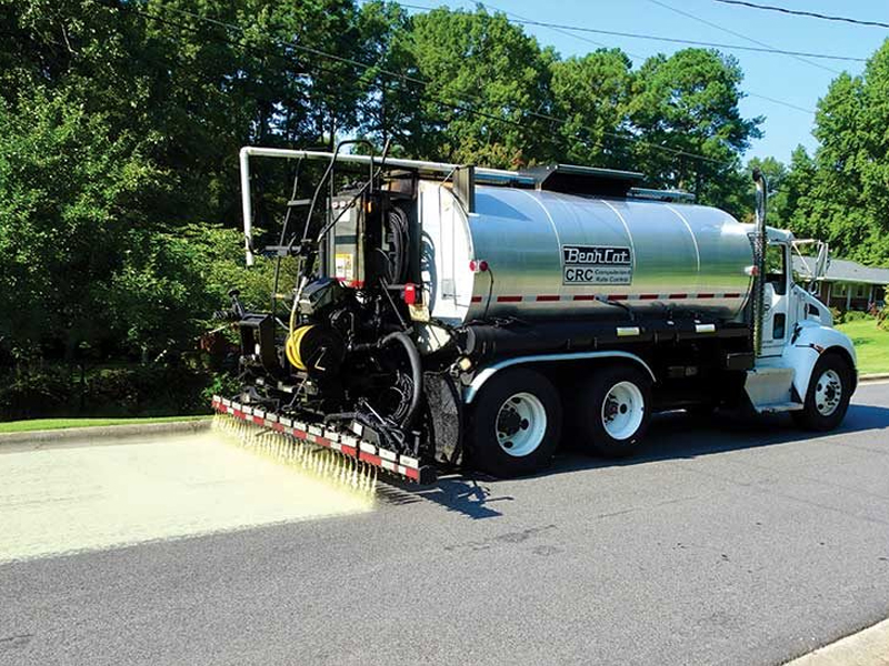 A vehicle applying roadway treatment to the asphalt.